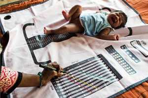 Indian child being measured on ASHA mat