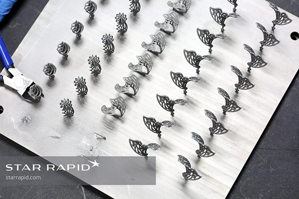 Cutting V. Nunes 3D printed jewelry off of built plate