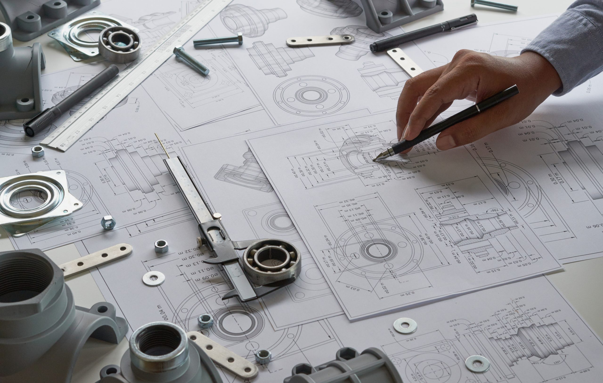Engineer technician designing drawings mechanicalÂ parts engineering Enginemanufacturing factory Industry Industrial work project blueprints measuring bearings caliper tools